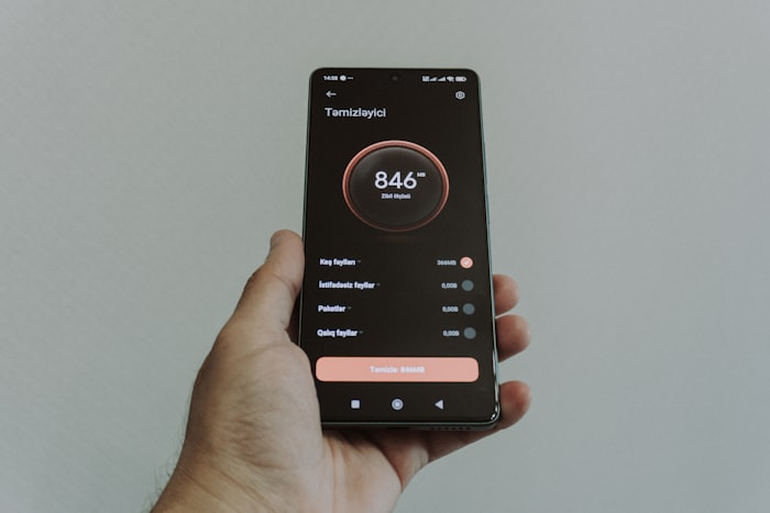 Hand holding a smartphone with an app interface